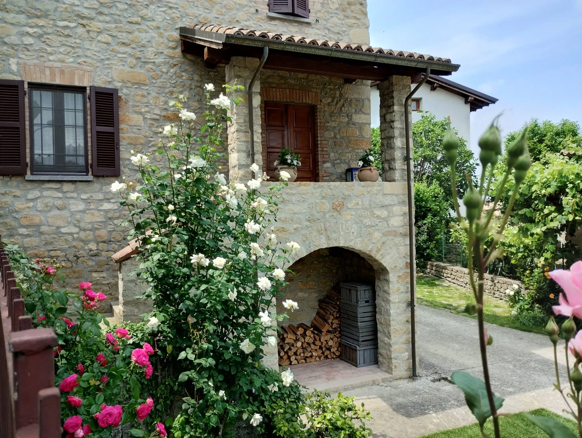 Casa La Pomella in pietra con rose e giardino